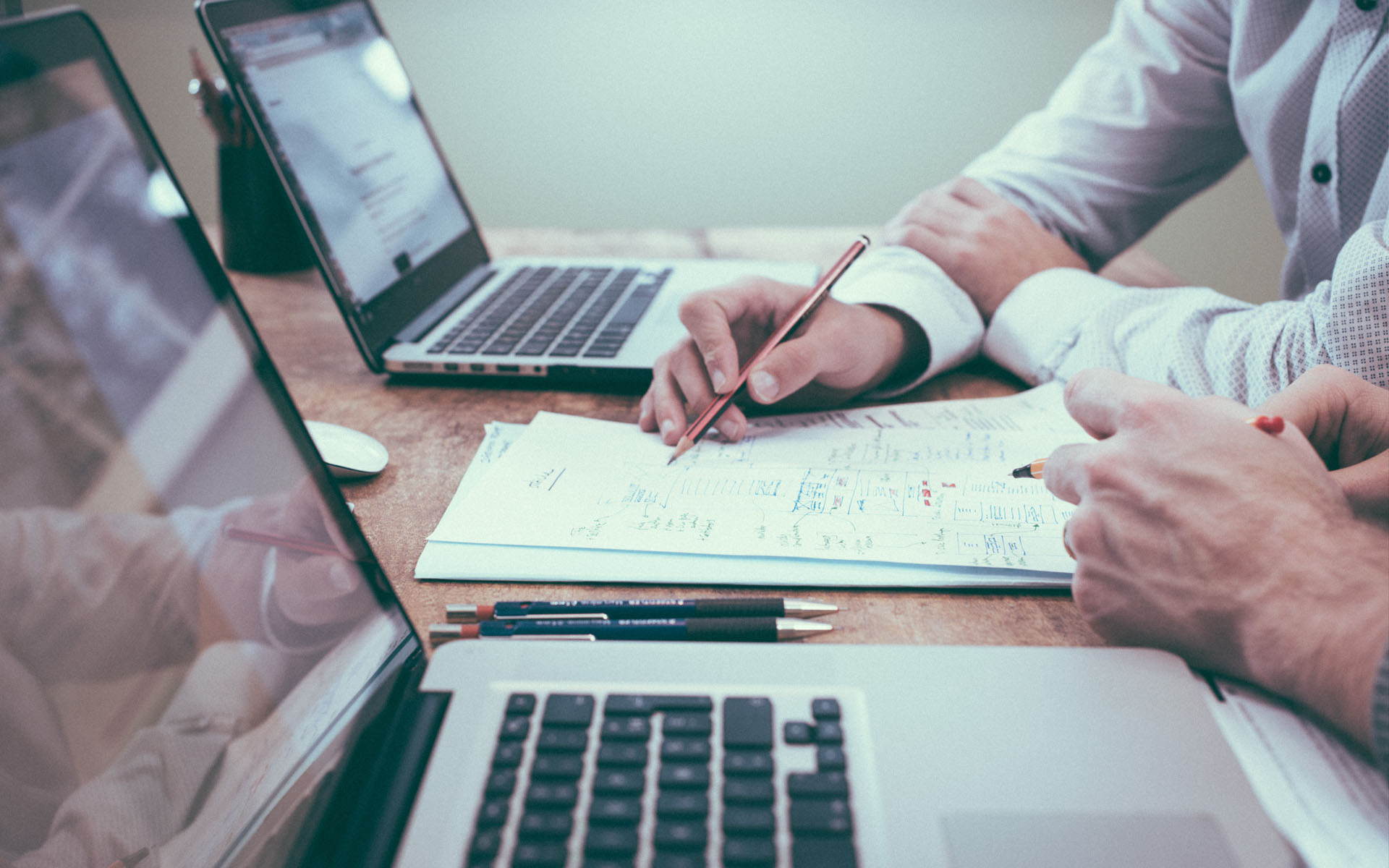 Two people reviewing a printed document with a pen, ready for client website approval